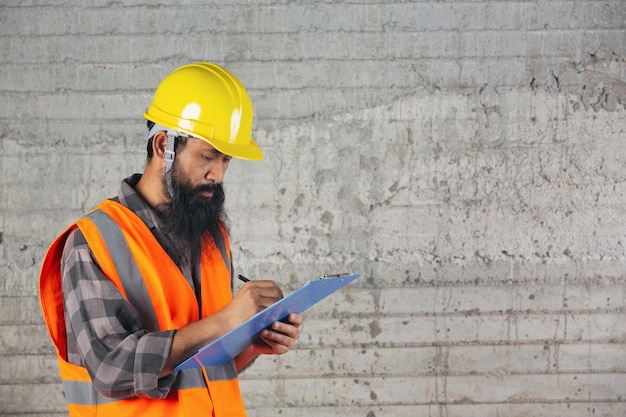 Trabajador de la construcción con documento, plan de trabajo para el interior del sitio de construcción del edificio.