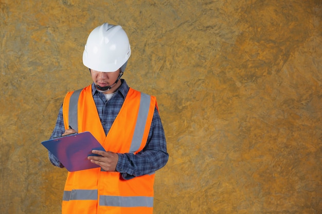 Trabajador de la construcción con documento, plan de trabajo para el interior del sitio de construcción del edificio.