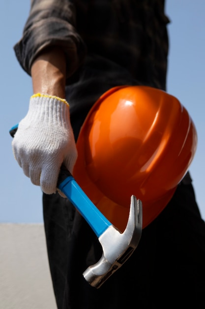 Trabajador de la construcción con martillo en el lugar de trabajo