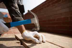 Foto gratuita trabajador de la construcción con martillo en el lugar de trabajo