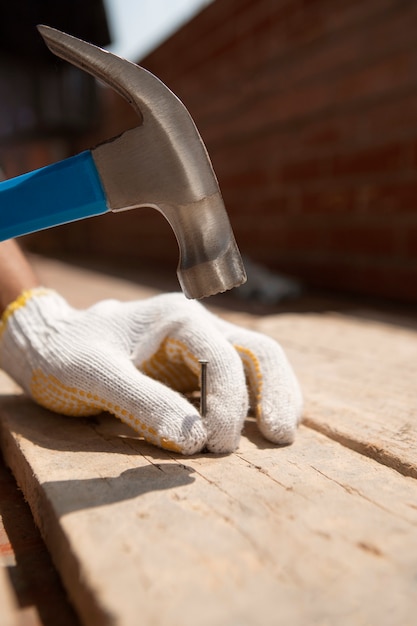 Foto gratuita trabajador de la construcción con martillo en el lugar de trabajo