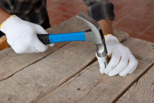 Trabajador de la construcción con martillo en el lugar de trabajo