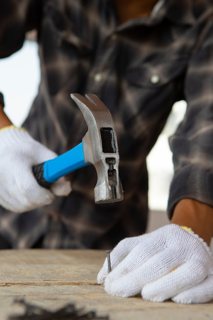 Trabajador de la construcción con martillo en el lugar de trabajo