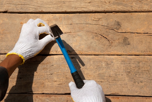 Trabajador de la construcción con martillo en el lugar de trabajo