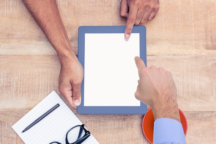 Foto gratuito trabajador enseñando a otro trabajador algo en la tablet