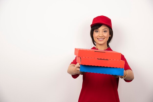 Trabajador de entrega de pizza mujer feliz dando tres cartones de pizza.