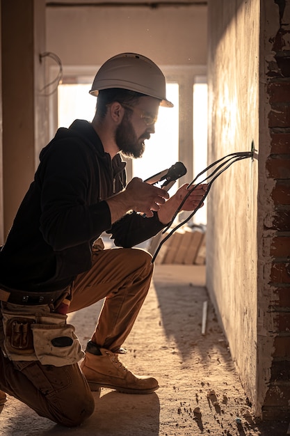 Trabajador está cortando cables con alicates de liniero