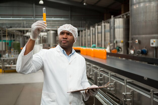 Trabajador examina el jugo en la fábrica.