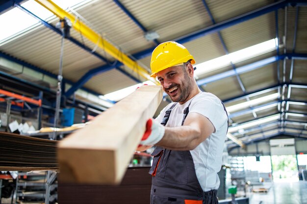 Trabajador de fábrica comprobando el material de madera para una mayor producción