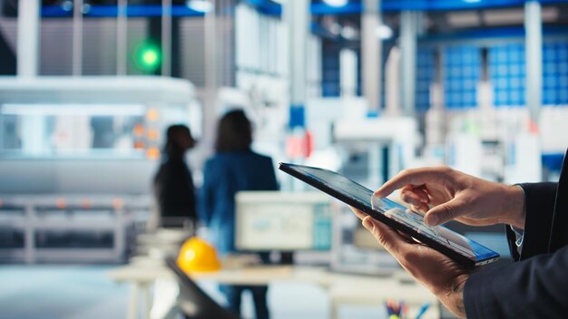 Un trabajador de una fábrica fotovoltaica utiliza un software de seguimiento en una tableta para diagnosticar el sistema