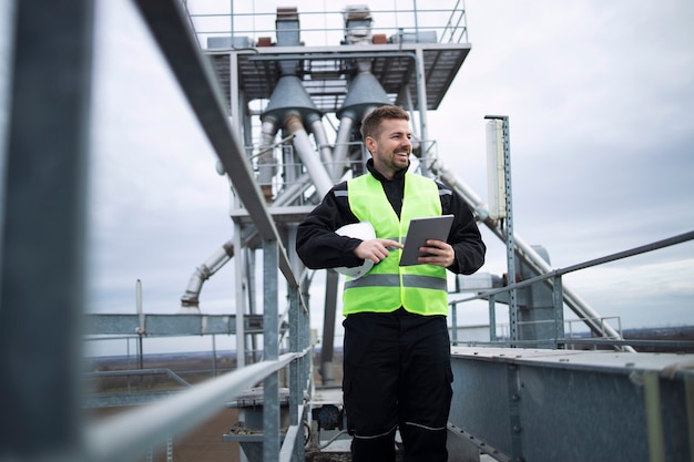 Trabajador de una fábrica industrial de pie sobre la construcción de alta metal de la planta de producción