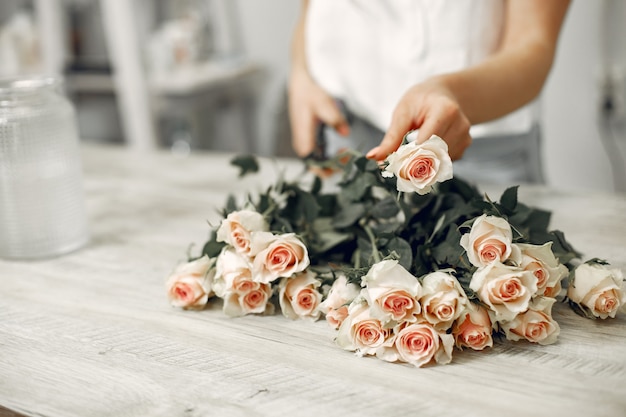 Trabajador con flores. La mujer hace un ramo. Linda chica trabajando