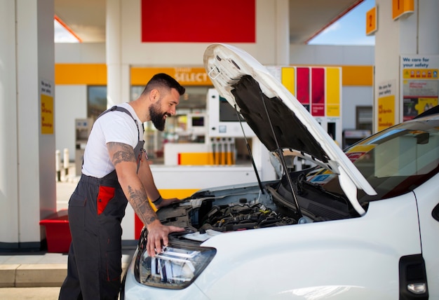 Foto gratuita trabajador de gasolinera cuidando el auto del cliente