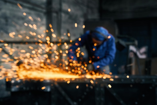 Trabajador haciendo puerta por máquina cortadora de acero eléctrica