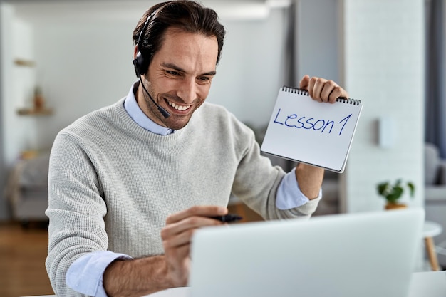 Trabajador independiente feliz que imparte clases de formación educativa sobre una computadora portátil desde casa