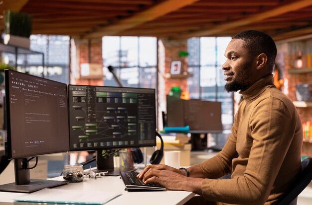 Un trabajador informático alegre usando una computadora en un innovador lugar de trabajo de Silicon Valley