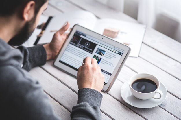 Foto gratuita trabajador leyendo noticias con la tableta