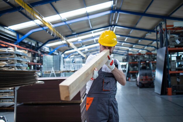 Trabajador de la línea de producción de carpintero comprobando el material de madera para la producción de muebles en la sala de la fábrica