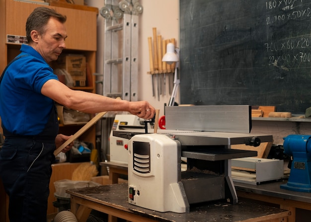 Foto gratuita trabajador de la madera en su taller trabajando con herramientas y equipos.