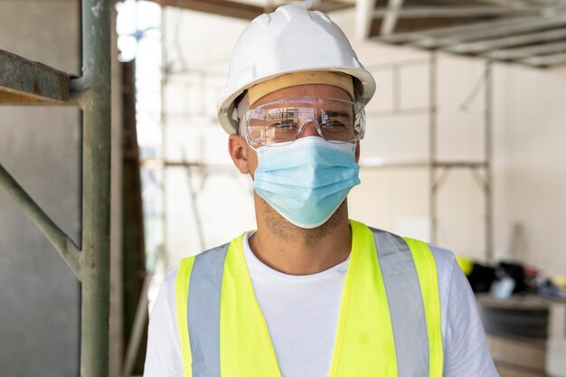 Trabajador con máscara médica en un sitio en construcción