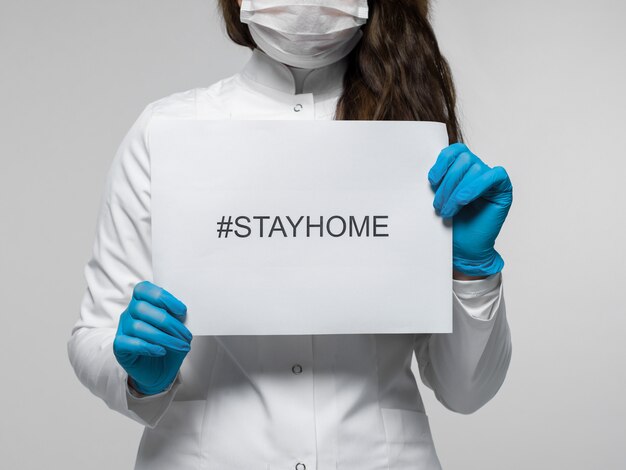 Trabajador médico con folleto con descripción stayhome