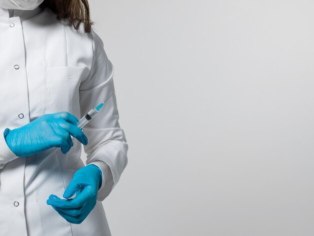Trabajador médico con inyección en uniforme médico blanco