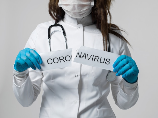 Trabajador médico rasga papel escrito sobre coronavirus