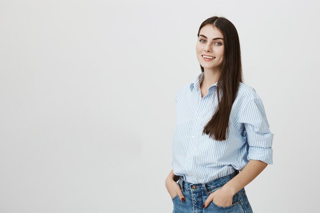 Trabajador de oficina femenino atractivo elegante en camisa y jeans