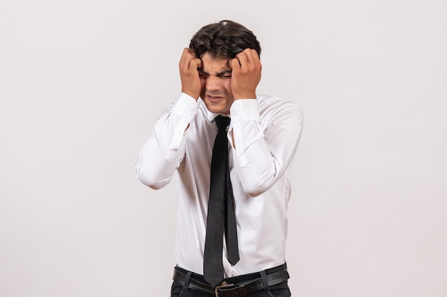 Foto gratuita trabajador de oficina masculino de vista frontal de pie sobre la pared blanca trabajo de trabajo masculino