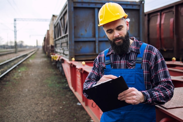 Trabajador que envía contenedores de carga para compañías navieras a través de un tren de carga y organiza las mercancías para su exportación.