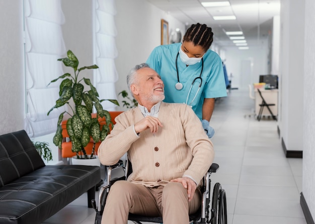 Trabajador de la salud de tiro medio ayudando al paciente