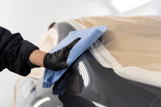 Trabajador de servicio pintando auto en servicio automático