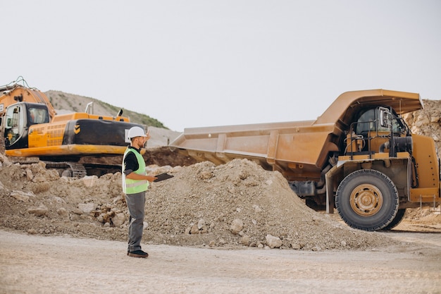 Trabajador de sexo masculino con bulldozer en cantera de arena