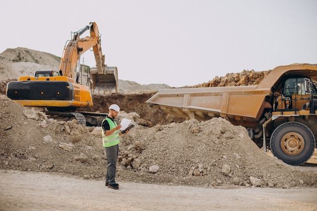 Trabajador de sexo masculino con bulldozer en cantera de arena