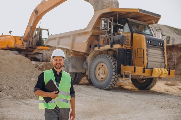 Trabajador de sexo masculino con bulldozer en cantera de arena