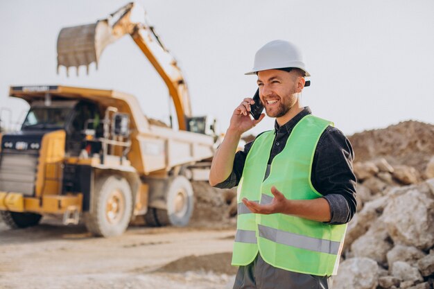 Trabajador de sexo masculino con bulldozer en cantera de arena