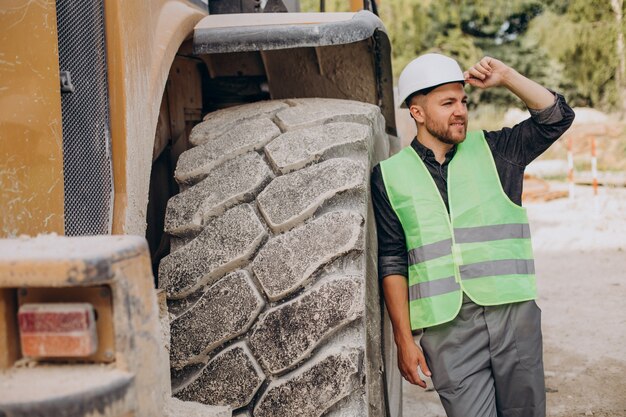 Trabajador de sexo masculino con bulldozer en cantera de arena