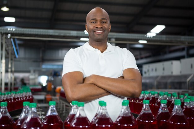 Trabajador de sexo masculino confidente que opera la máquina en la fábrica de bebidas frías