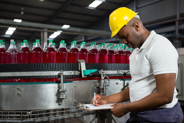 Trabajador de sexo masculino observando los productos en la fábrica.