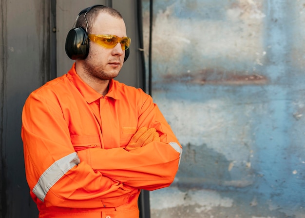 Foto gratuita trabajador de sexo masculino en uniforme con gafas protectoras y auriculares