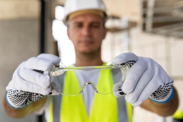 Foto gratuita trabajador en un sitio de construcción usando equipo de protección