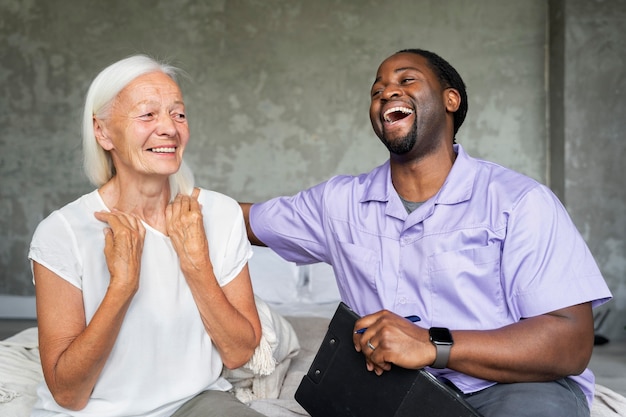 Foto gratuita trabajador social cuidando a una anciana