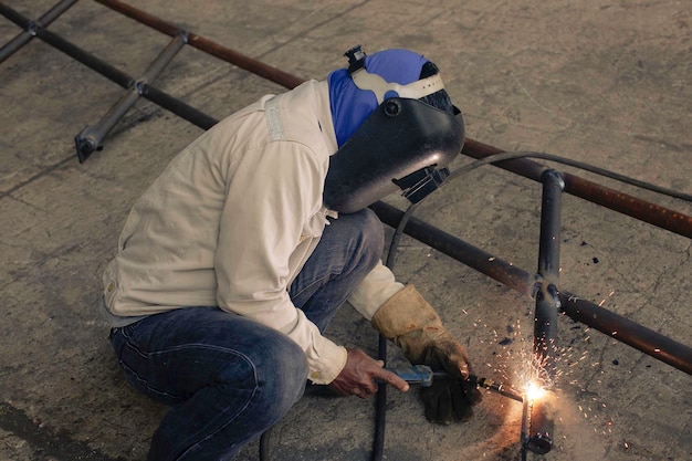El trabajador de soldadura de metal es parte de la construcción de tuberías de boquillas de maquinaria, petróleo y gas.