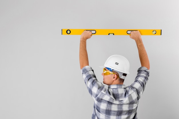 Trabajador sosteniendo un nivel de burbuja en la pared