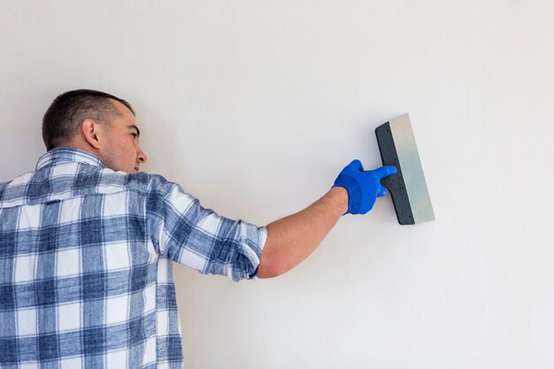 Trabajador sosteniendo una paleta en la pared