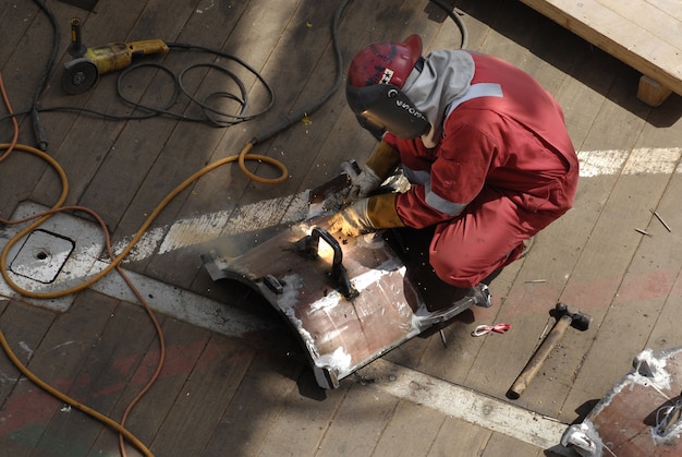 Trabajador en el traje de trabajo que fija el estante de metal