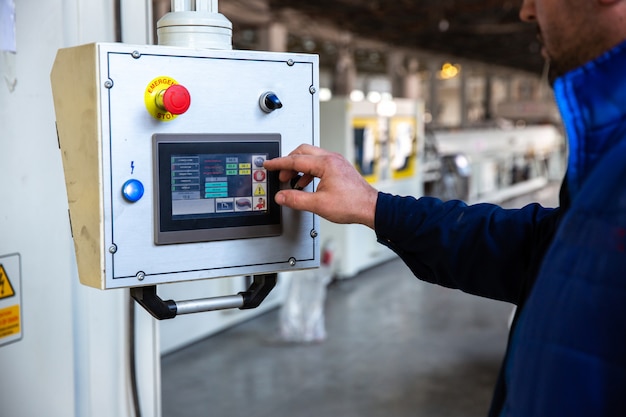 El trabajador usa el panel de control en la fábrica