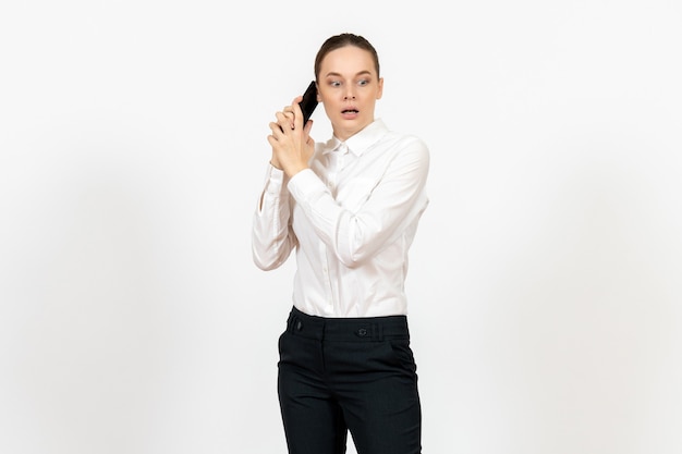Trabajadora en elegante blusa blanca hablando por teléfono asustada en blanco