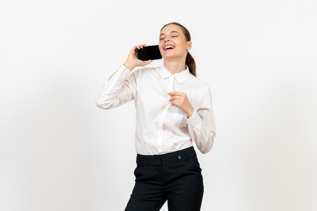 Trabajadora en elegante blusa blanca hablando por teléfono en blanco