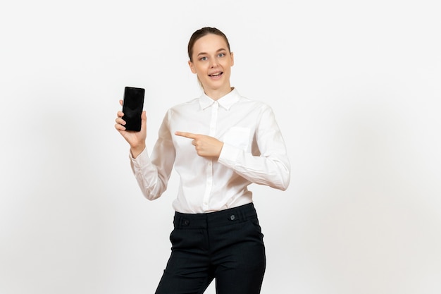 Trabajadora en elegante blusa blanca sosteniendo su teléfono en blanco